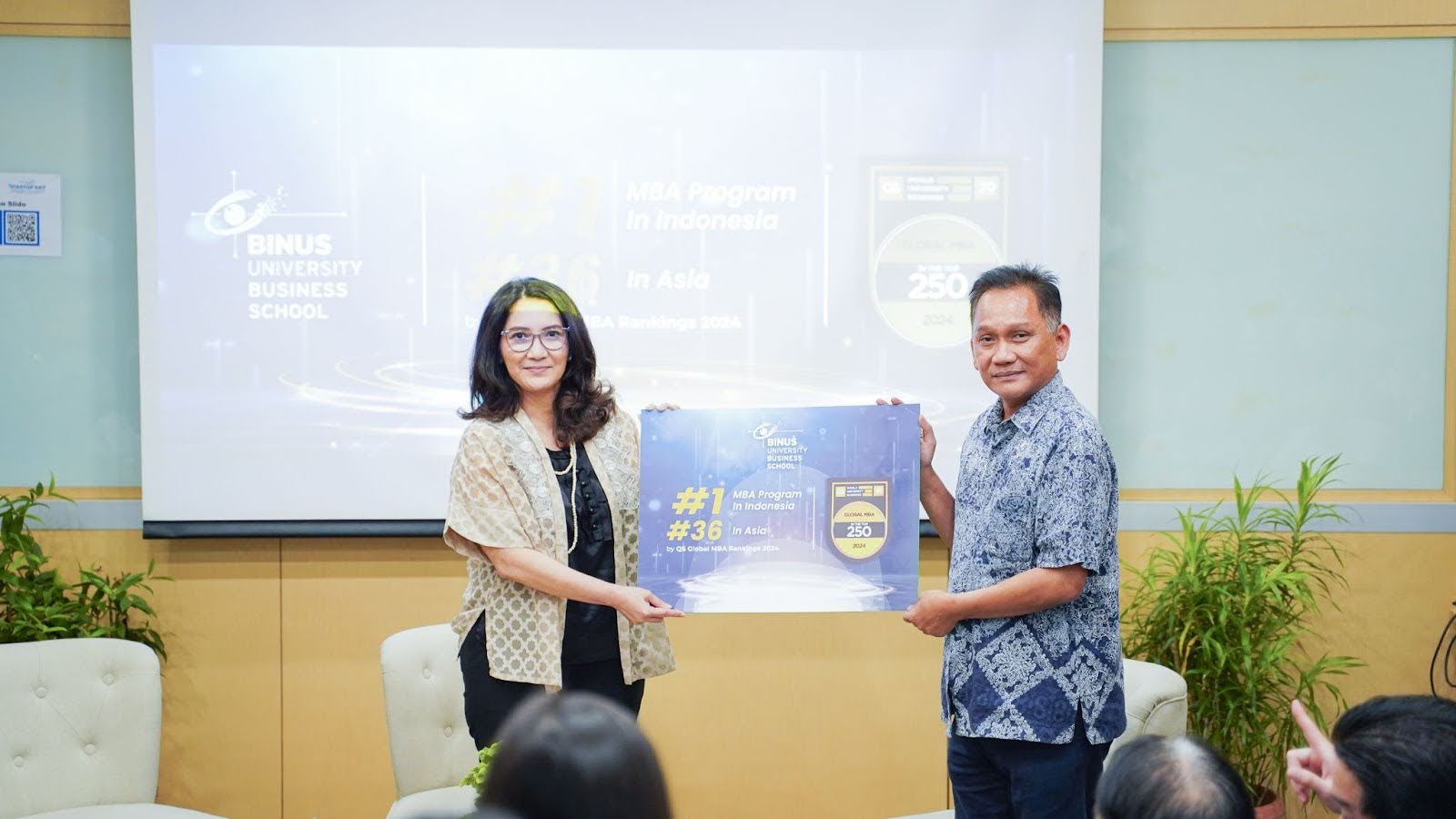 (Simbolis pengumuman resmi pencapaian BINUS Business School di QS Global MBA 2024 yang menjadikan BBS sebagai MBA program terunggul di Indonesia. Diterima oleh Dr. Rini Setiowati - Dekan BBS Master Program dari Dezie L. Warganegara sebagai Executive Dean BBS)